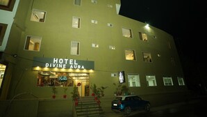 A multi-story hotel with a sign reading "HOTEL DIVINE AURA."