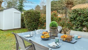 Une table dressée à l’extérieur, avec une variété de plats et une petite plante en pot.