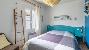 Une chambre à coucher avec un lit, une échelle, une fenêtre et une étagère fixée au mur.