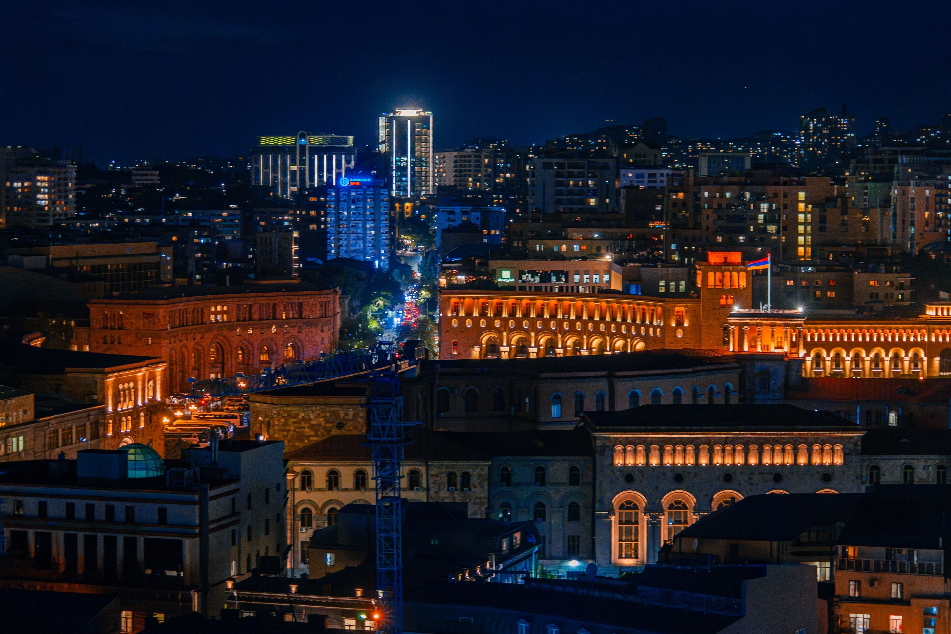 A cityscape at night with illuminated buildings and a prominent tower.