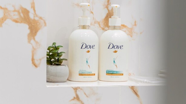 Two Dove products on a marble surface with a small plant. - Sunset Apart-Hotel (Yerevan)