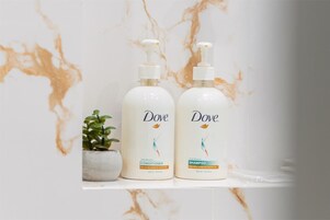 Twee Dove producten op een marmeren oppervlak met een kleine plant.