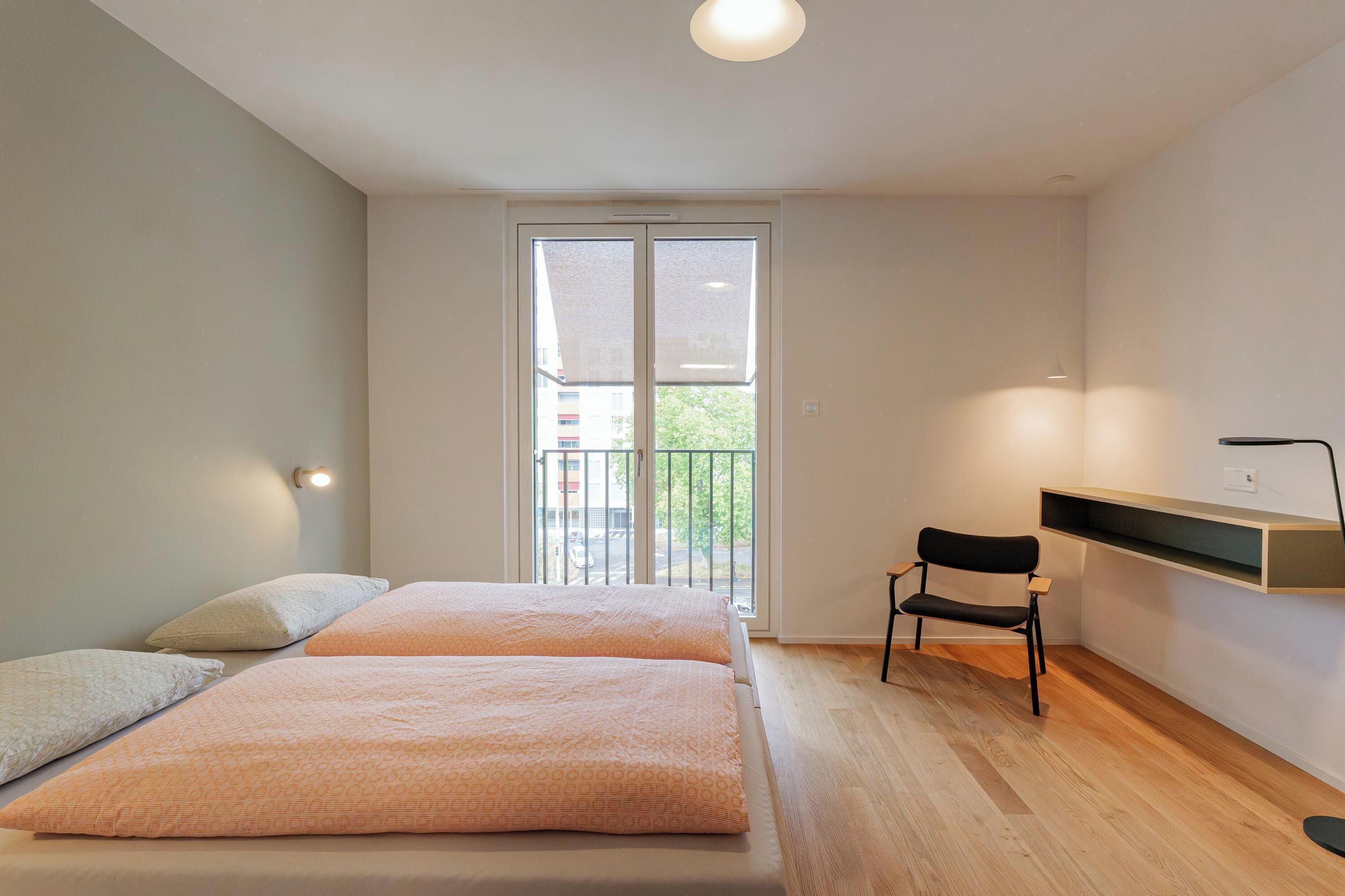 Une chambre moderne avec une grande fenêtre, un bureau et une chaise.