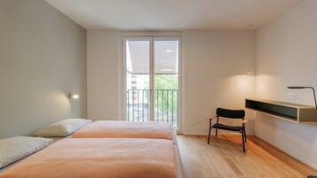 Une chambre moderne avec une grande fenêtre, un bureau et une chaise.