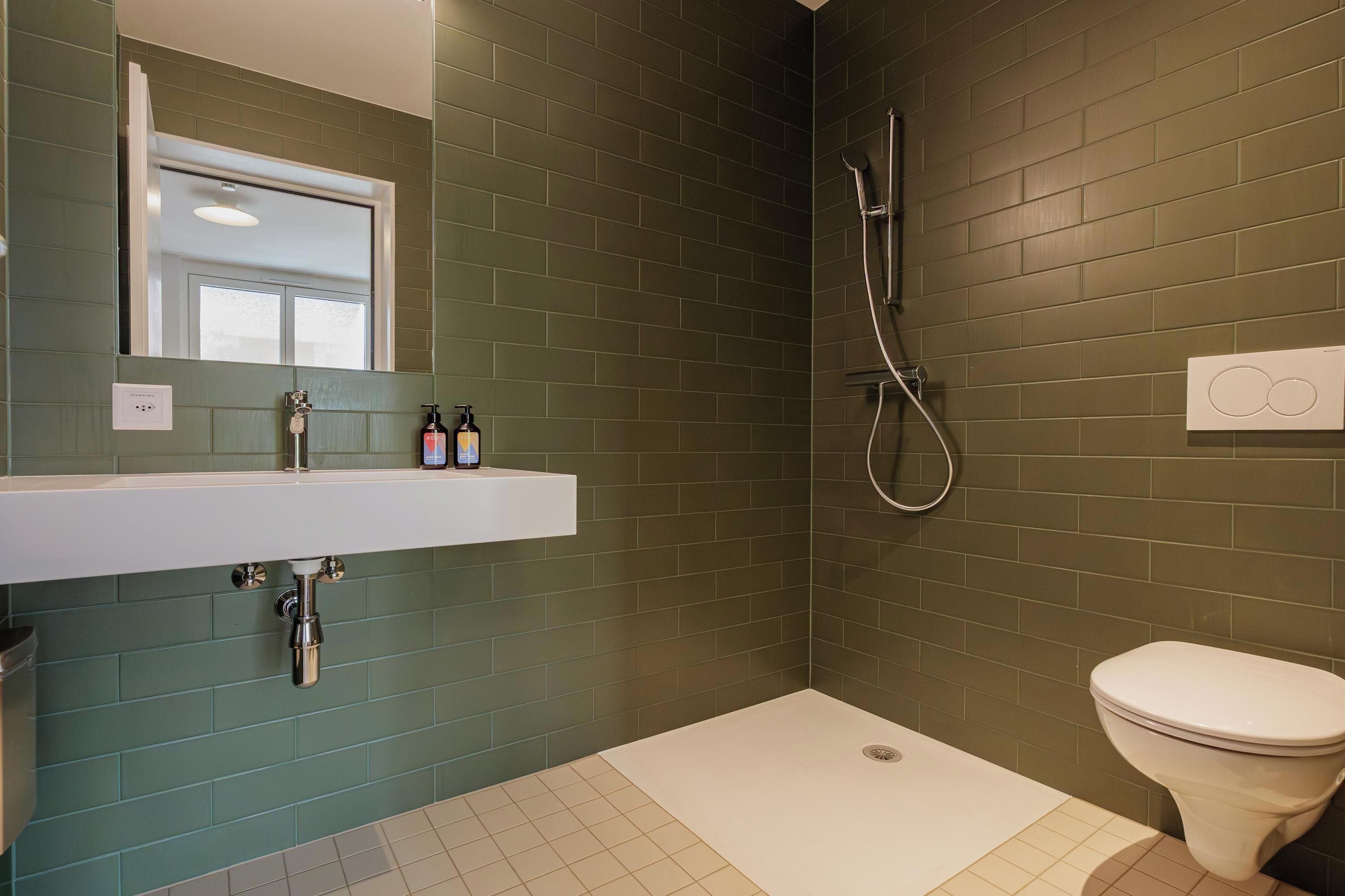 A bathroom with a white sink, a toilet, and a shower.