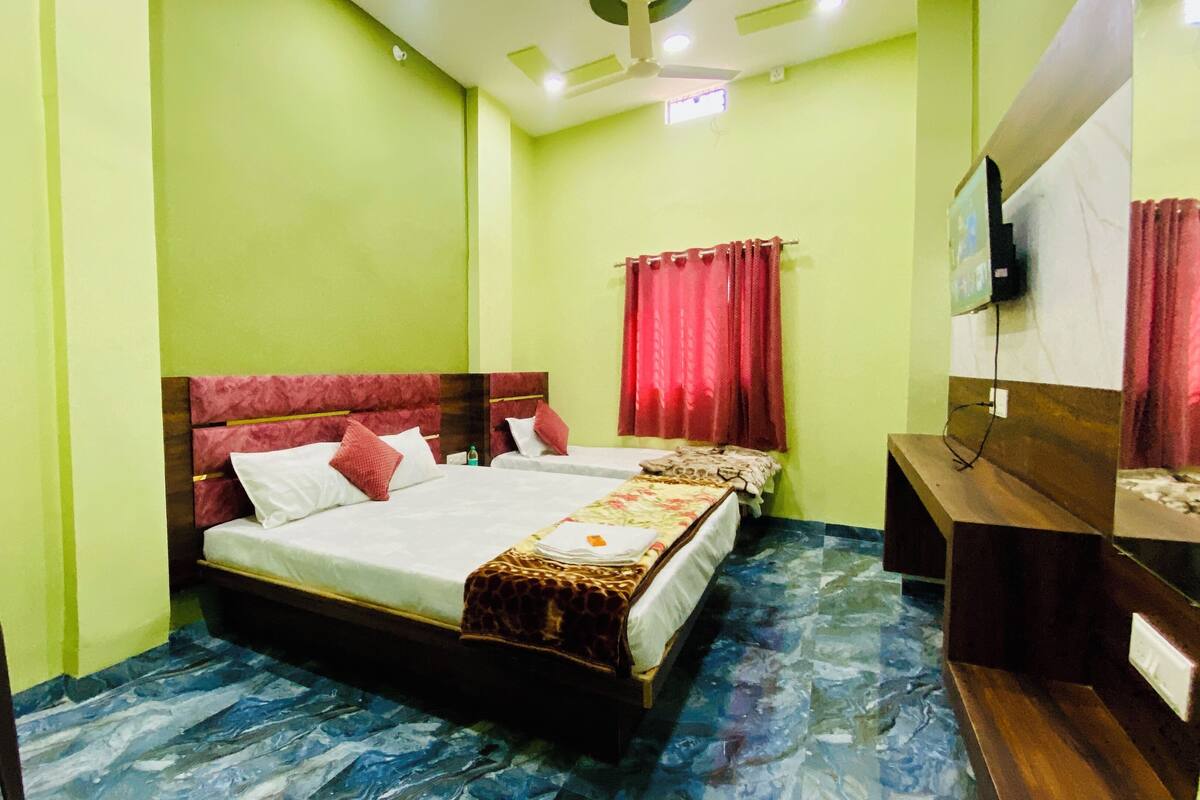 A hotel room with a large bed, a desk, and a chair.