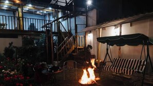 An outdoor patio area with a fire pit, a swing chair, and a staircase leading to an upper level. - Casa tradicional en cusco (Cusco)