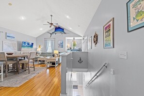 Un salon moderne avec une table à manger en bois, un canapé et un ventilateur de plafond.