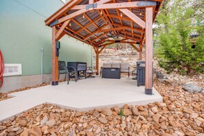 An outdoor patio area with a wooden pergola, seating, and a grill. - < 1 Mi to Comal Park: Peaceful Duplex w/ Yard! (Canyon Lake)