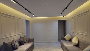 A modern living room with two sofas, patterned cushions, recessed ceiling lighting, and a neutral color scheme. - Landmark Hostel Cairo (Cairo)