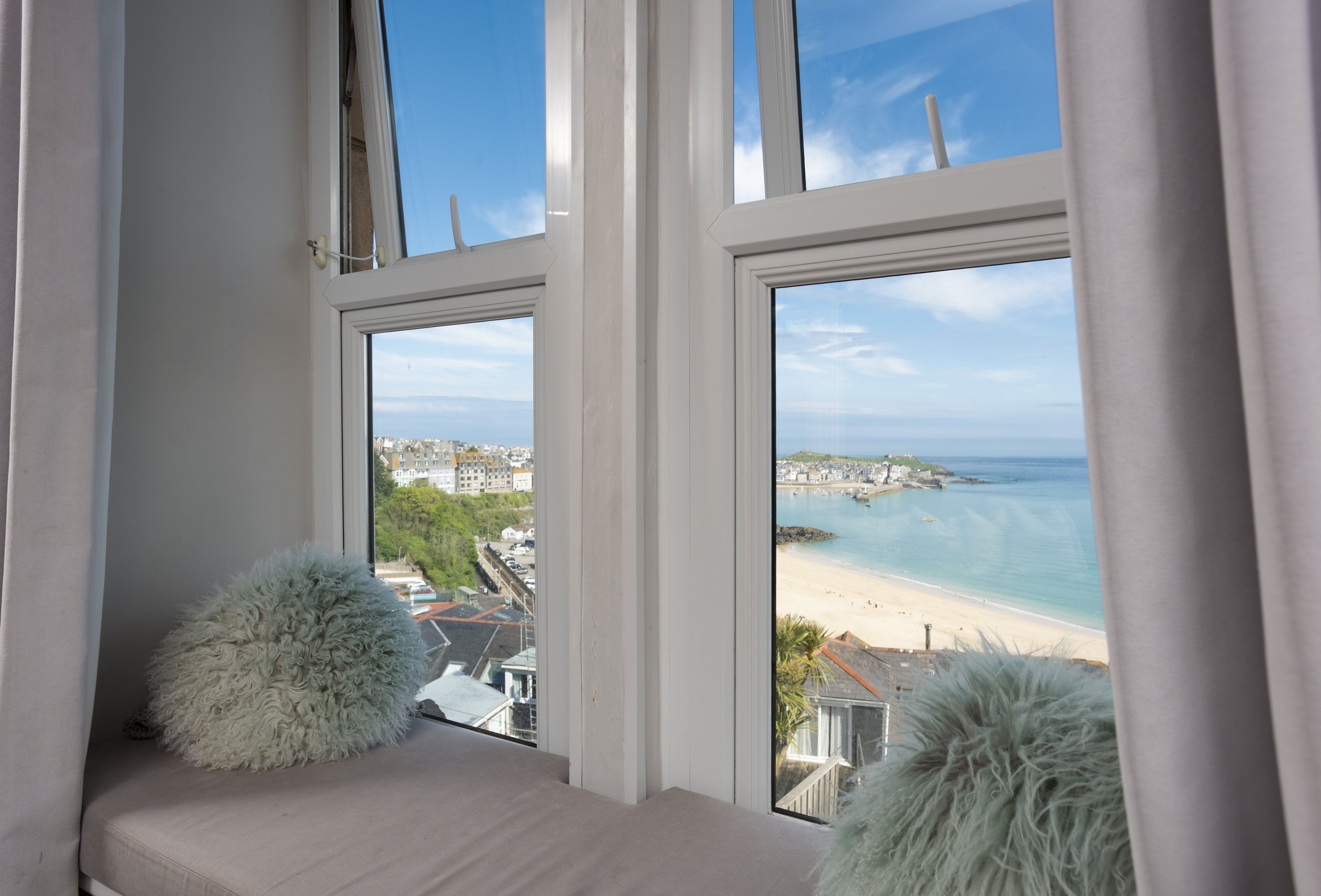 Ein Fenster mit Blick auf Strand und Stadtlandschaft.