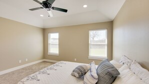A bedroom with a bed, two windows, a ceiling fan, and a carpeted floor. - 8 Mi to State Park: Home w/ Fenced Yard in Lindale (Lindale)