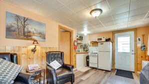 Tunnelmallinen olohuone, jossa on nahkainen nojatuoli, puinen sohvapöytä ja seinällä taulu.