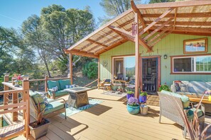 A wooden deck with outdoor furniture, a pergola, and potted plants.