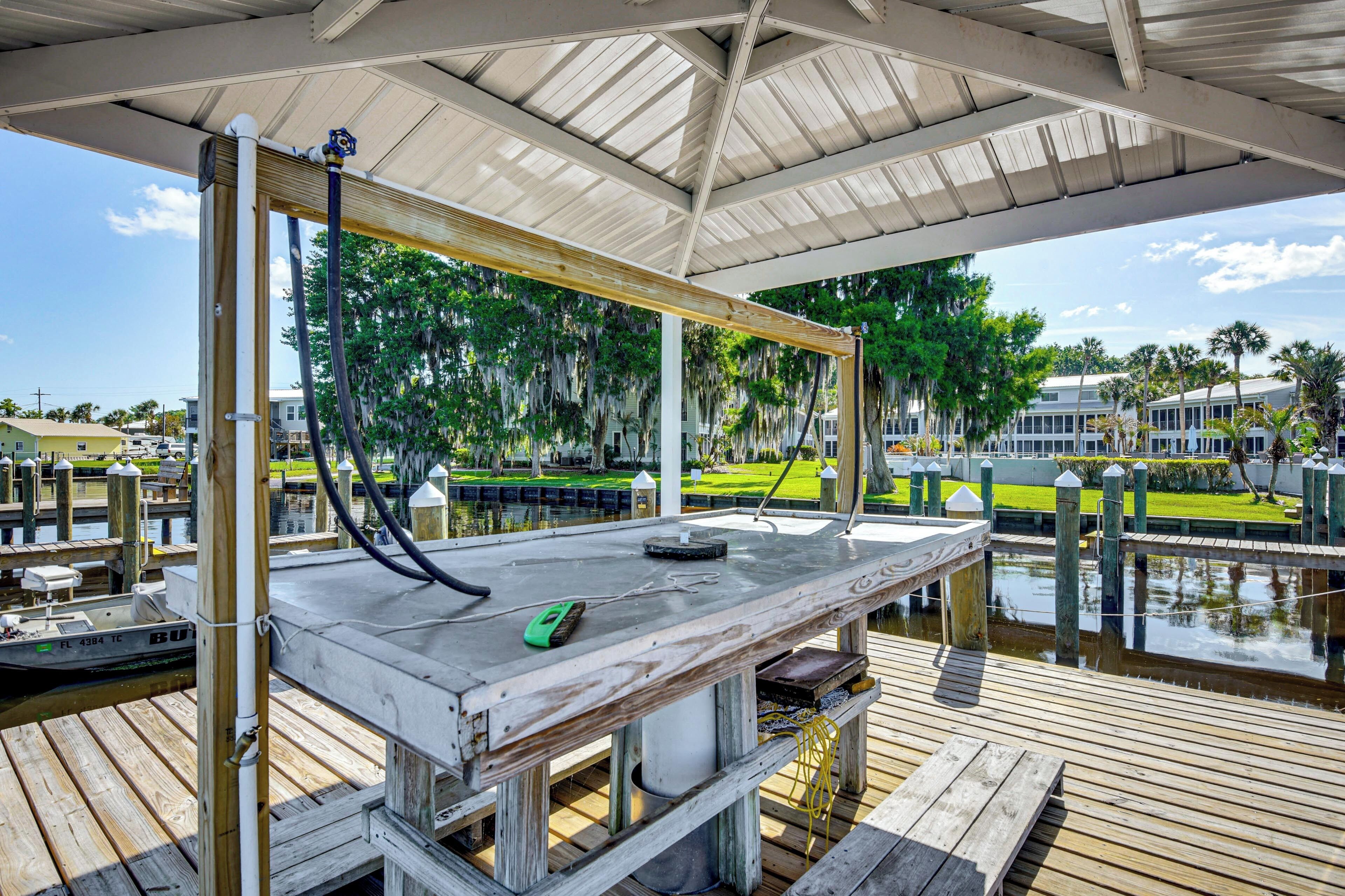A covered dock with a table, a green device, and a water pump.