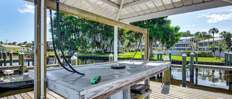 A covered dock with a table, a green device, and a water pump.
