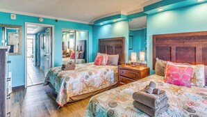 A hotel room with two beds, a wooden headboard, a nightstand, and a mirror. - Sun, Sand & Sea Views: Myrtle Beach Condo (Myrtle Beach)