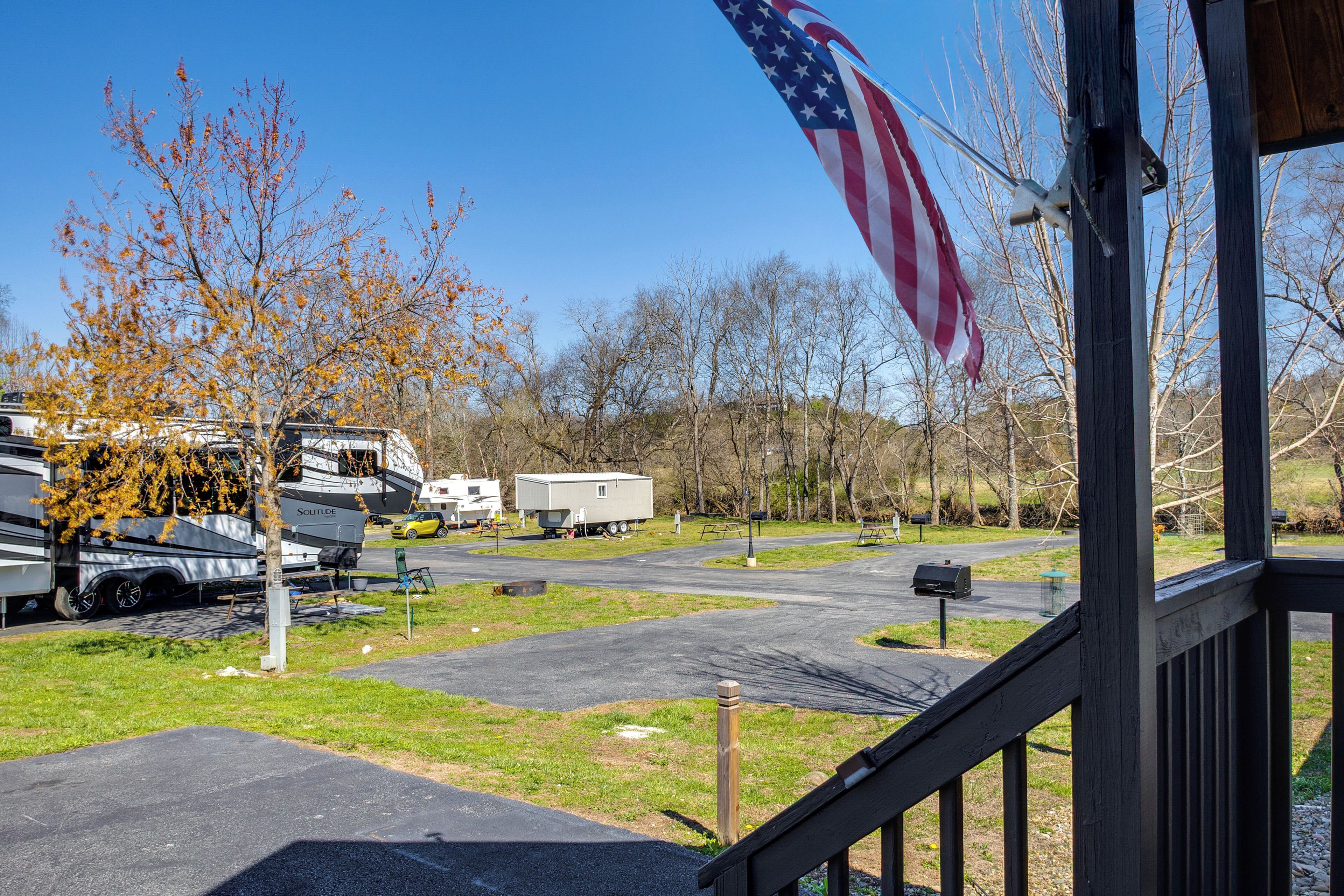 A campground with RVs parked, a flag, and a mailbox.
