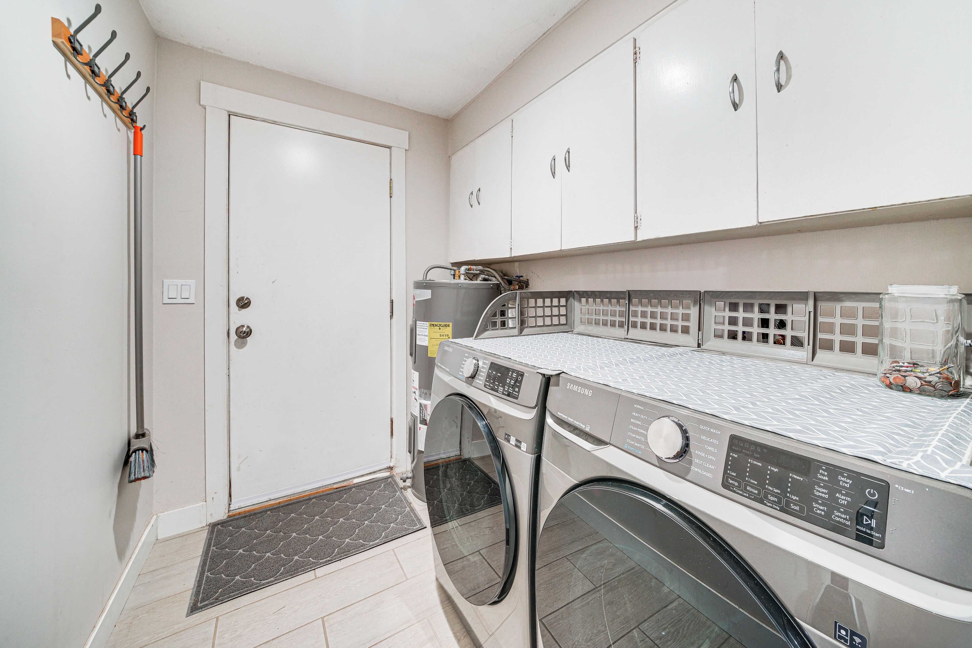A laundry room with a washing machine, dryer, and a drying rack.