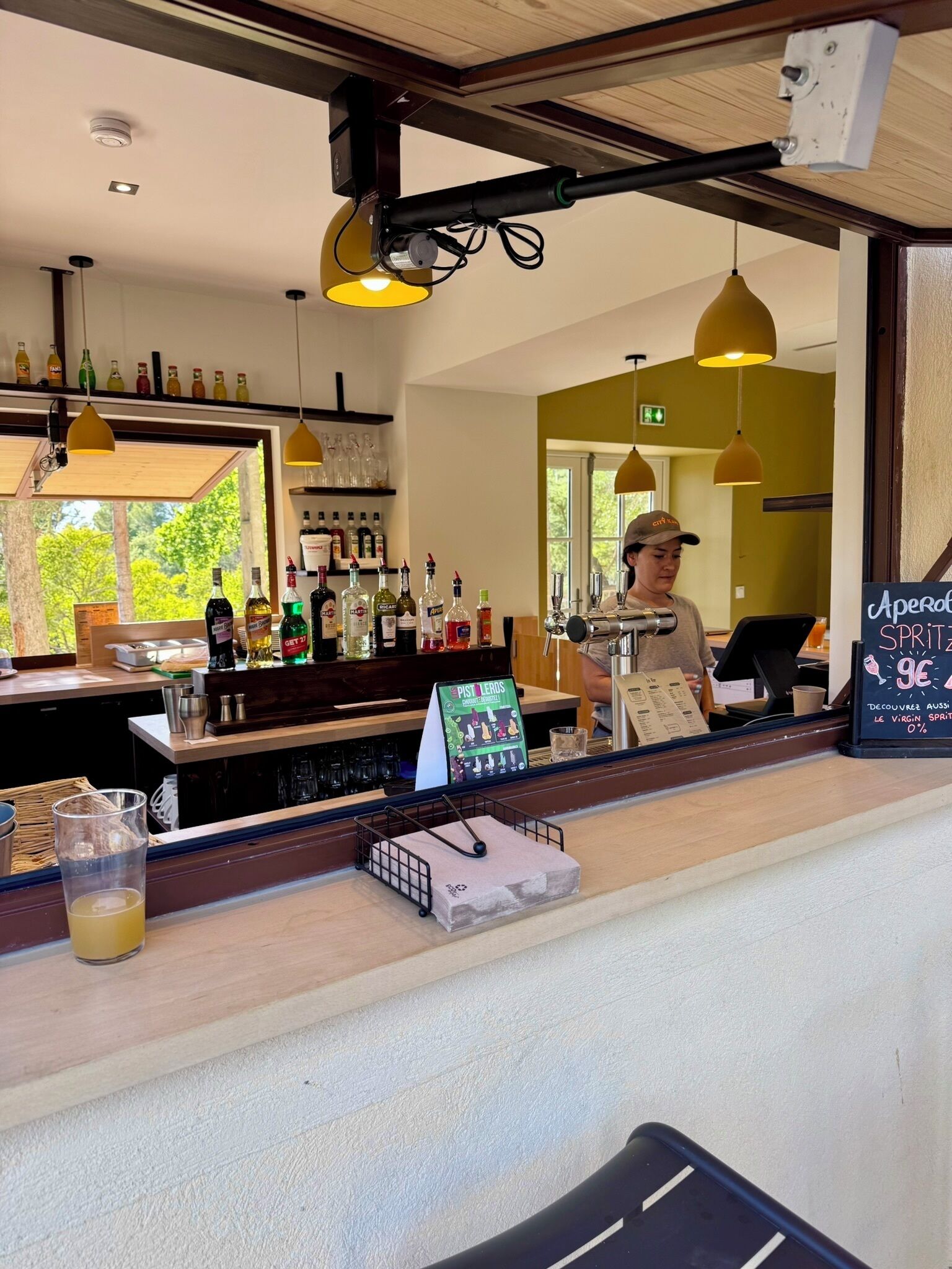 Eine Bar mit Theke, verschiedenen Flaschen und einer Speisekarte.