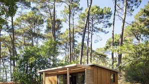 A wooden cabin with a porch and outdoor seating area, surrounded by trees. - CityKamp d'Aix en Provence  (Aix-en-Provence)