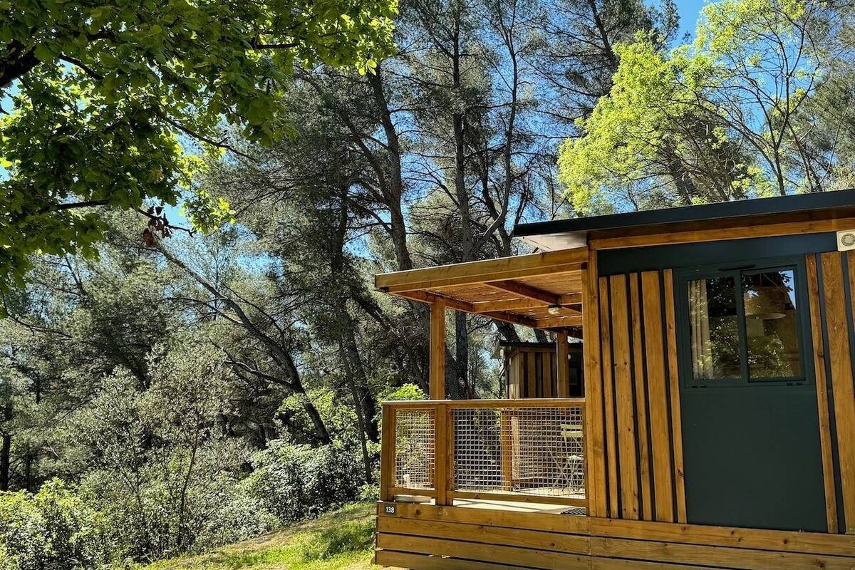Eine Holzhütte mit Balkon, umgeben von dichtem Wald.