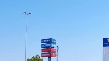 A parking lot with a signpost listing various brands.