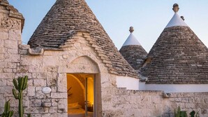 A stone building with conical roofs and a doorway leading to a room.