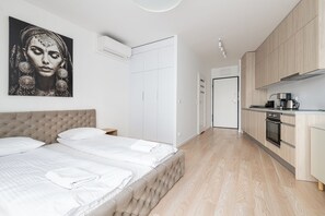Un dormitorio moderno con una cama grande, una mesita de noche y un armario.