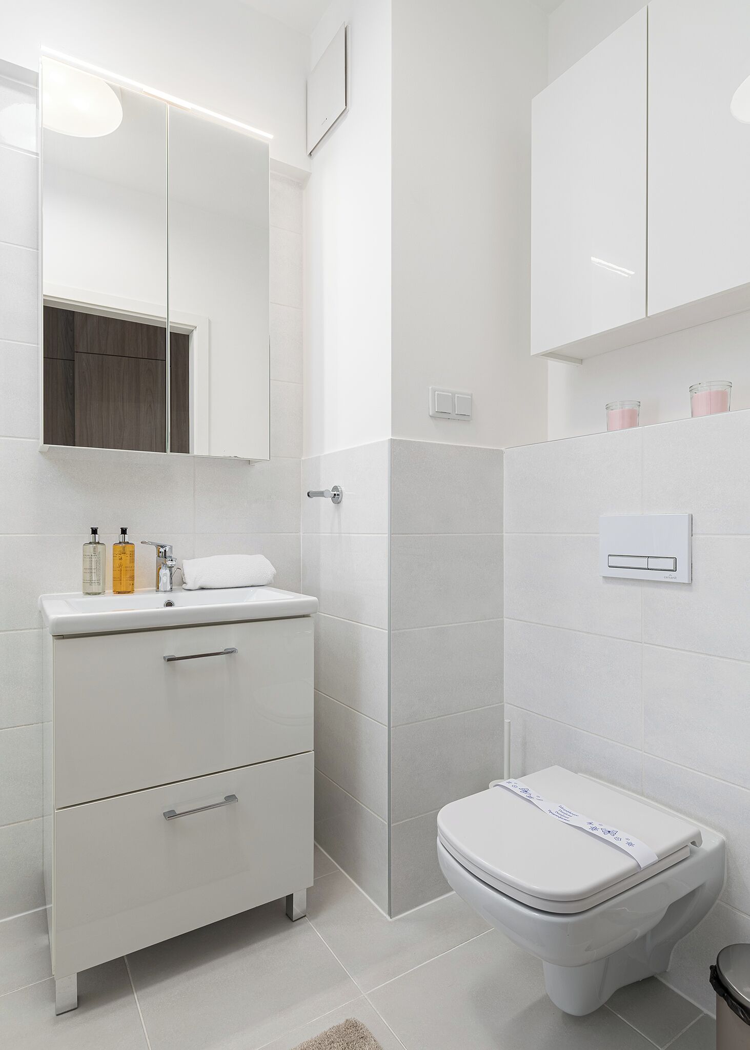 A modern bathroom with a white vanity, a toilet, and a shower area.