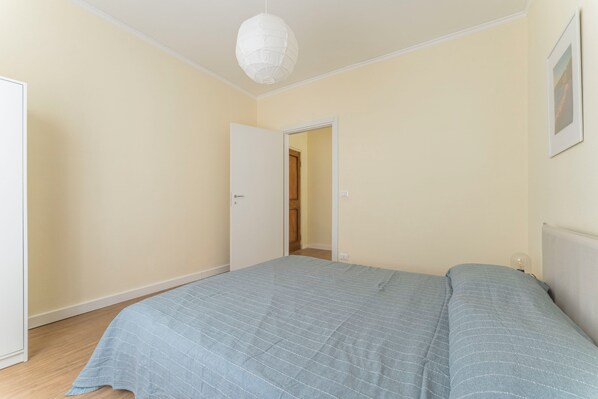 A bedroom with a bed, a door, and a light fixture. - Spacious Apartment In Sori With Terrace (Sori)