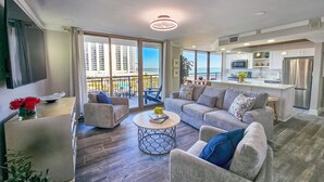 A modern living room with a sofa, coffee table, and a view of the ocean. - Superbly updated ocean view condo, 303 Brighton, full access (Myrtle Beach)