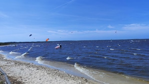 A beach with clear skies and calm waters, suitable for water activities.