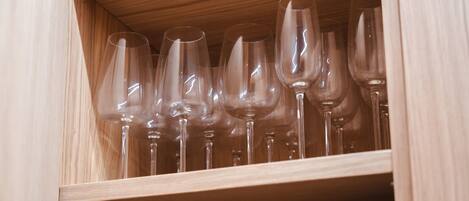 A wooden cabinet with multiple wine glasses neatly arranged inside.