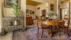 A dining area with a round wooden table, chairs, and a patterned carpet. - From the Baron and Baroness, charm and art's house with terrace (Palermo)