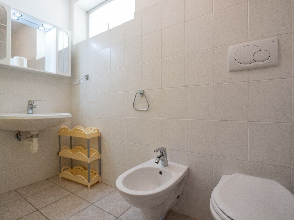 Bany amb rentatge, bidet, vàter i mirall amb barra de tovalloles.