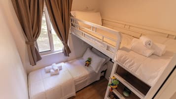 Cozy single-room accommodation with a bunk bed setup featuring two neatly made beds and a small shelf.