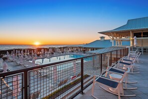 A rooftop pool area with lounge chairs and umbrellas, overlooking the ocean at sunset. - Watercolor Home with LSV and Ping Pong (Santa Rosa Beach)