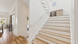 A staircase with white railings and wooden steps leading to a landing. - Watercolor Home with LSV and Ping Pong (Santa Rosa Beach)