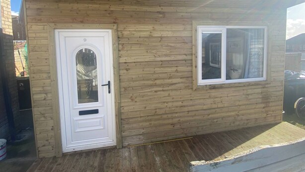 A wooden building with a white door and a window. - R and B Warm and Cosy Cabin (Londonderry)