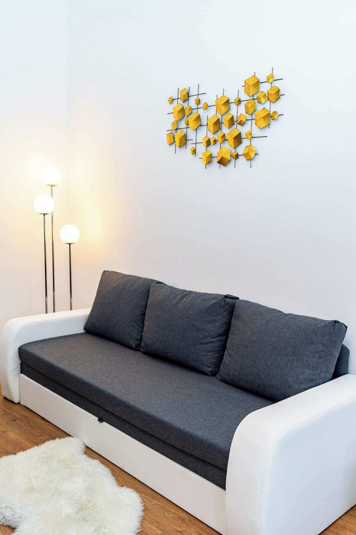 Una sala moderna con un sofá gris, un tapete blanco y una obra de arte geométrica amarilla en la pared.