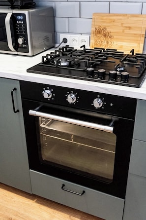 A kitchen with a built-in oven, a microwave, and a gas stove.