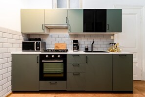 Een moderne keuken met een inbouwoven, magnetron en koffiezetapparaat.