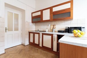 Una cocina con armarios de madera, encimera, tostadora y frutero.