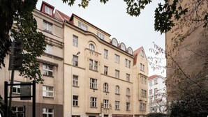 A multi-story building with a row of parked cars in front. - Victory King's Residence (Prague)