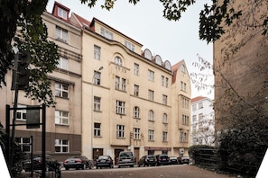 A multi-story building with a row of parked cars in front.