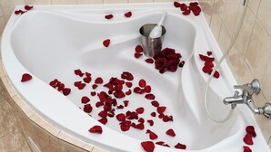 A bathtub with red rose petals and a champagne bottle. - Victory King's Residence (Prague)