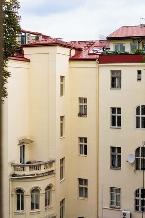 A multi-story building with a red roof, multiple windows, and balconies.