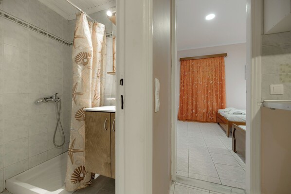 Un baño con ducha, inodoro y lavabo.
