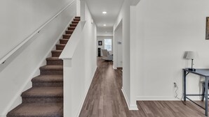 A modern interior with a carpeted staircase, a wooden floor, and a desk with a lamp. - Quiet Retreat Perfect for Families 5 Bedroom Home (Rocky Mount)